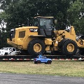 Boy in a toy truck looks at a front end loader.